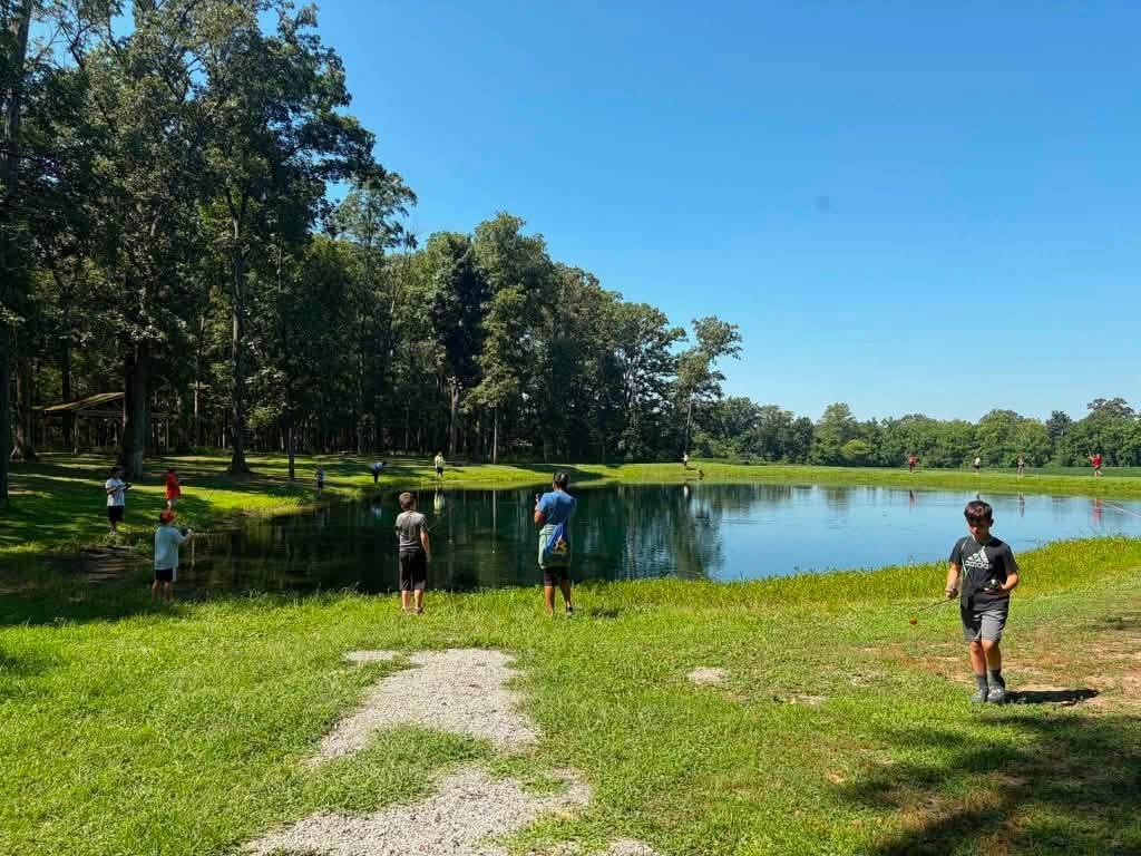 Campers fishing at the camp pond